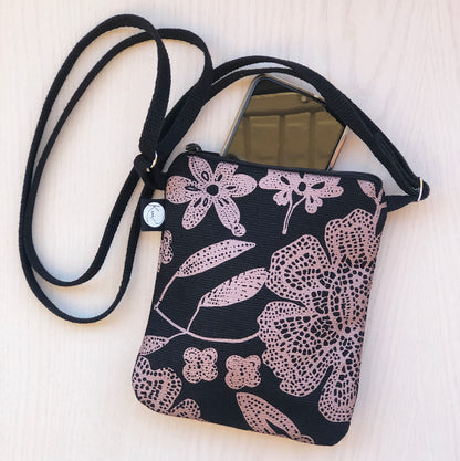 Lähikuva Kui designin Hulda-pikkulaukusta. Pohjaväri musta, kuparin värisiä kukkia.